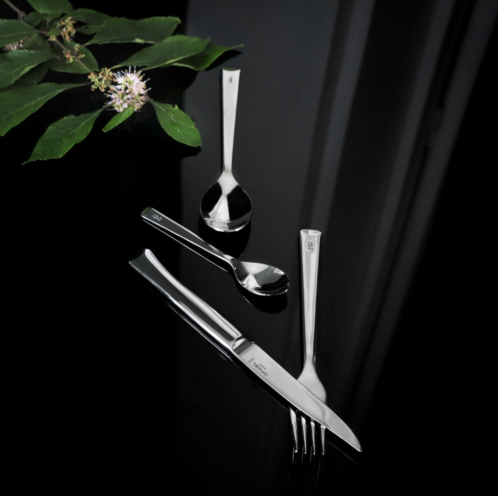 close up photo of the opinel perpetue range with a plant on the side. premium cutlery set for the table